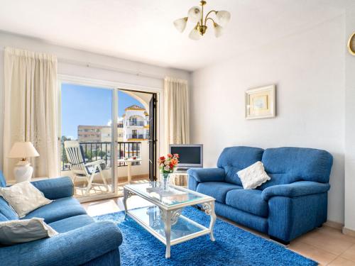 un soggiorno con 2 divani blu e un tavolo in vetro di Apartment Imperial Puerto-2 by Interhome a Torremolinos