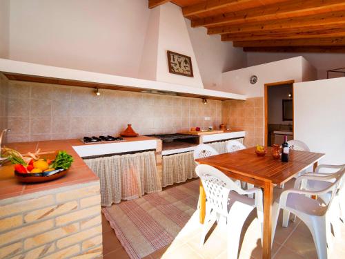 eine Küche mit einem Holztisch und weißen Stühlen in der Unterkunft Holiday Home Vicent by Interhome in Serrallonga