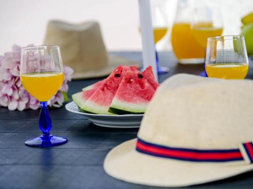 a table with two glasses of wine and a plate of watermelon at Villa Vila Hortencia by Interhome in Ericeira