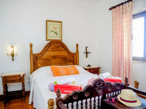 a bedroom with a wooden bed with hats on it at Villa Vila Hortencia by Interhome in Ericeira