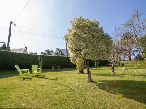 a yard with two chairs and a tree at Studio Les Genêts by Interhome in La Richardais