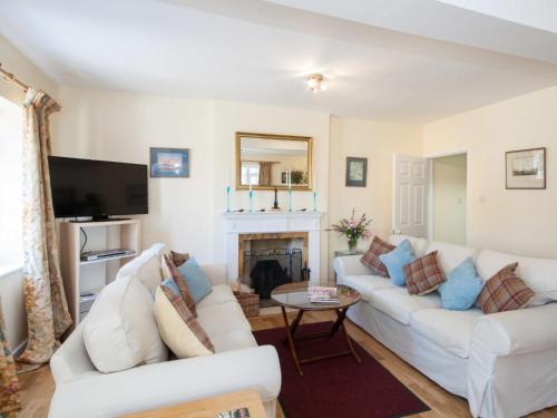 uma sala de estar com dois sofás brancos e uma lareira em Holiday Home The Carriage House by Interhome em Worton