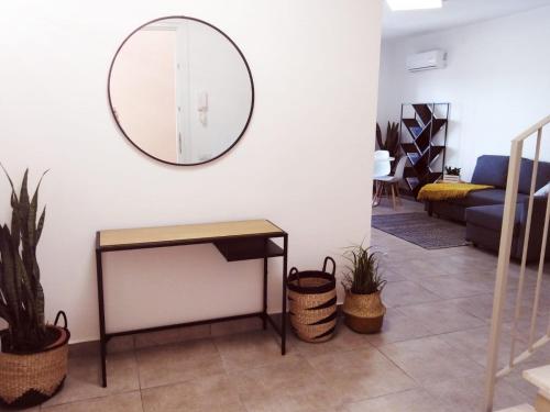 a mirror on the wall in a living room with plants at Appartamenti Shardana in Villasimius