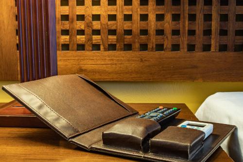 a wallet and a remote control sitting on a table at Aanari Hotel & Spa- Mauritius in Flic-en-Flac