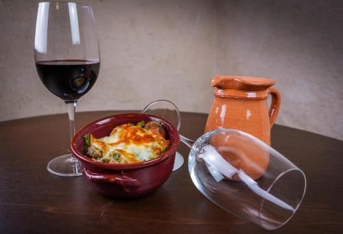 a table with a bowl of food and a glass of wine at Palazzo Cestari Hotel in Montesano sulla Marcellana