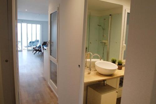 a bathroom with a sink and a shower and a mirror at SitgesNow Port Alegre Mar in Sitges
