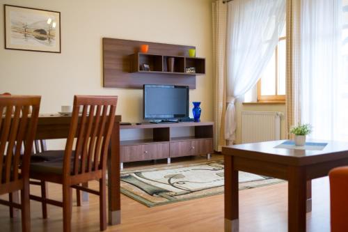 a living room with a table and a television at Aparthotel Bellamonte in Zakopane