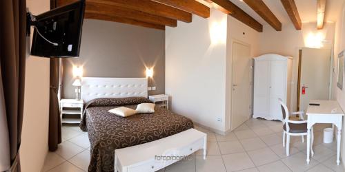 um quarto com uma cama, uma secretária e uma televisão em Albergo Roma em Borgo Val di Taro