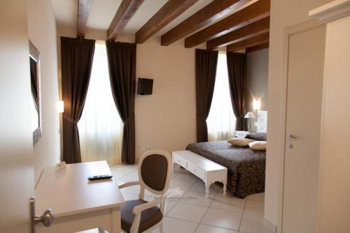um quarto com uma cama, uma secretária e uma mesa em Albergo Roma em Borgo Val di Taro