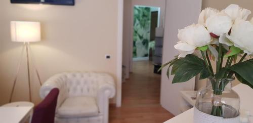 a vase of white roses in a living room at Fior Di Loto Rooms in Cagliari