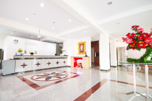 a large kitchen with a large flower pot with red flowers at White House Bizotel in Bangkok