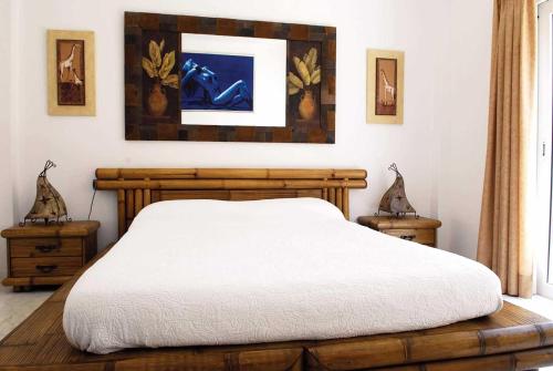 プエルト・デ・サンティアゴにあるRoyal Sunsetのベッドルーム1室(木製ベッド1台、ナイトスタンド2台付)