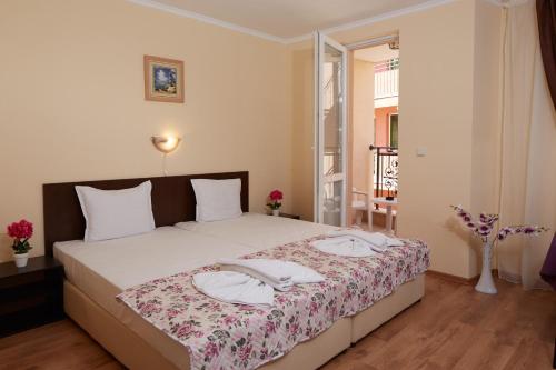 a bedroom with a large bed with two napkins on it at Feniks Apartments in Nesebar