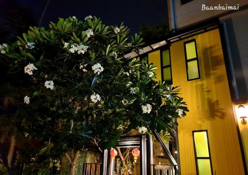 a vase filled with flowers next to a building at Baan Baimai Boutique Room in Phra Nakhon Si Ayutthaya