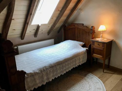 a bedroom with a bed and a lamp on a table at Den Haegepreeck in Horebeke