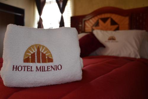 a hotel milwaukee pillow sitting on a bed at Hotel Milenio Nanacamilpa Tlaxcala in Nanacamilpa