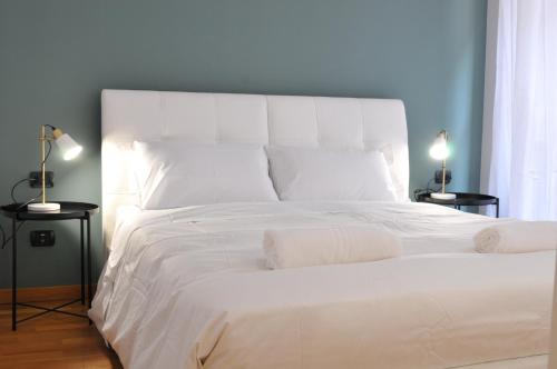 ミラノにあるResidenza Fiori Oscuriの白いシーツと枕が備わる大きな白いベッド
