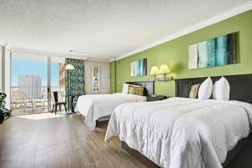 a hotel room with two beds and a balcony at Ocean Annie's Resorts in Myrtle Beach