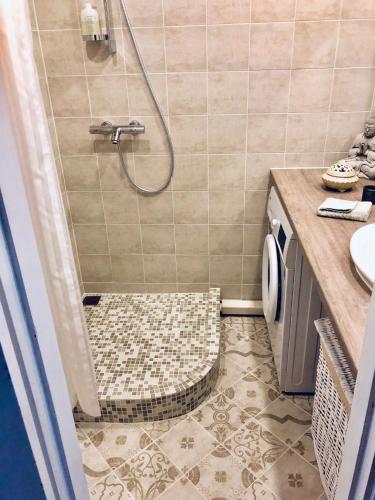 a bathroom with a shower with a tiled floor at Wind Rose apartment in Kuressaare