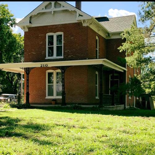 a brick house with a large yard in front of it at Smithville Historical Museum and Inn in Smithville