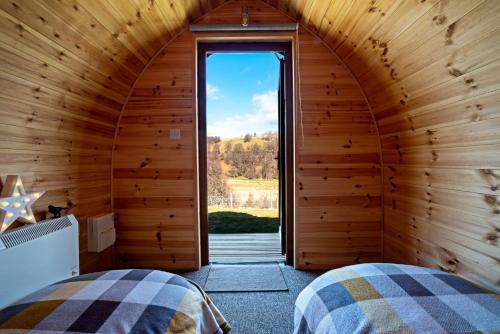 2 camas en una habitación con ventana grande en Howe of Torbeg, en Ballater