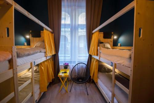 a room with three bunk beds and a window at InVerve Hostel in Timişoara