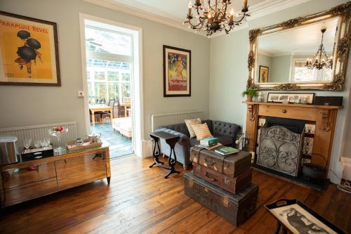 a living room with a fireplace and a mirror at Treherne House & The Malvern Retreat in Great Malvern
