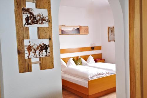 a bedroom with a bed and pictures on the wall at Pension Hatzis in Laion