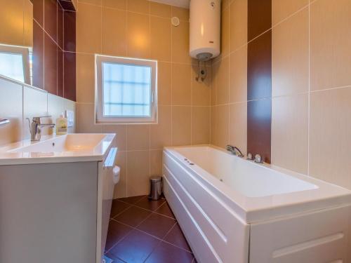 ein Badezimmer mit einer großen Badewanne und einem Waschbecken in der Unterkunft Villa CARPE DIEM in Selce
