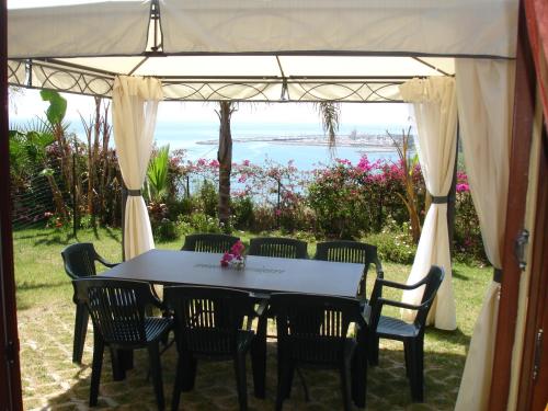 un tavolo e sedie sotto una tenda con vista sull'oceano di Villa del Mare Ligure a Santo Stefano al Mare