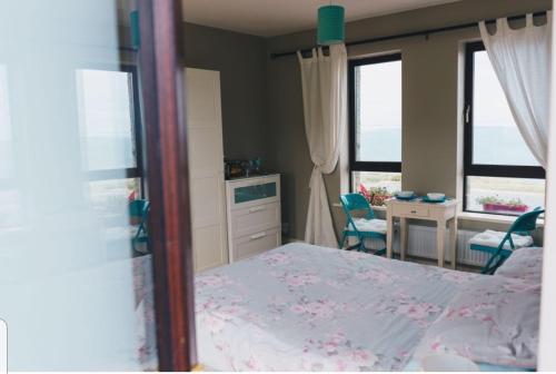 Un dormitorio con una cama y un escritorio y dos ventanas. en Our View, en Doolin