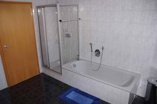 La salle de bains est pourvue d'une douche et d'une baignoire. dans l'établissement Ferienwohnung im Hainertal, à Heigenbrücken