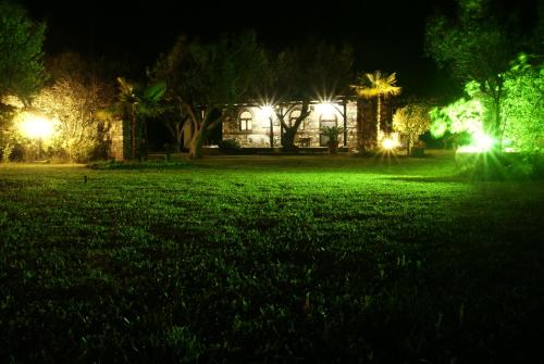 a house with lights in a park at night at Feggaropetra by the Sea(Moonstone) - Trani Ammouda in Ormos Panagias