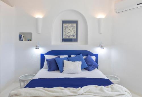 a blue and white bed in a white room at Villa Ravino Secret Retreat in Ischia