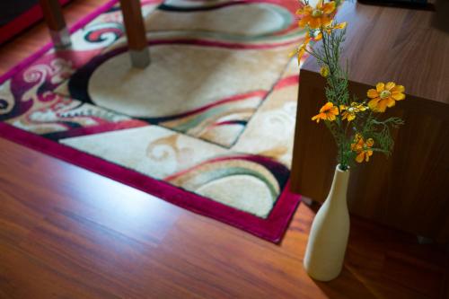 a white vase with flowers in it on a table at Aparthotel Bellamonte in Zakopane