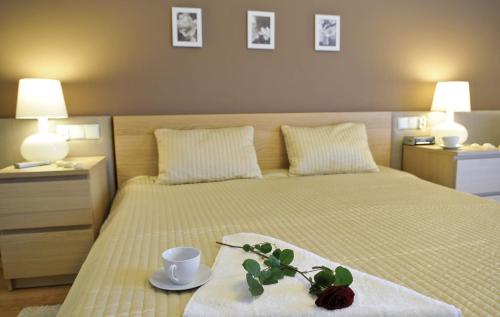 a bedroom with a bed with a tray with a flower on it at IRS ROYAL APARTMENTS Apartamenty IRS Fregata in Gdańsk