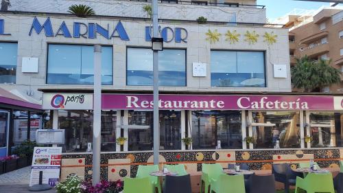 a restaurant with tables and chairs in front of a building at Magnificas vistas al mar in Oropesa del Mar