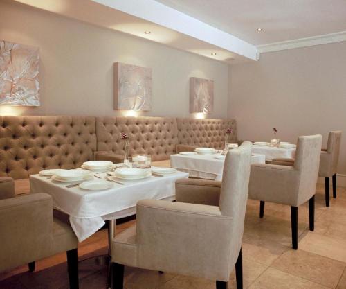 a dining room with a table and chairs and tablesktop at Banksia Boutique Hotel & Spa in Cape Town