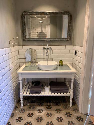 ein Bad mit einem Waschbecken und einem Spiegel in der Unterkunft The Piano Shop in Gränna