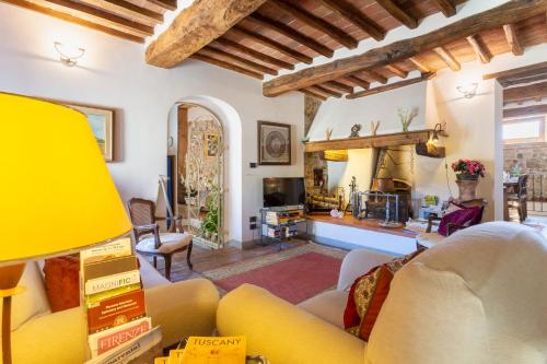 a living room with a yellow couch and a fireplace at Casale Le Masse in Greve in Chianti
