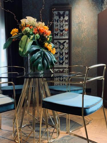 a vase of flowers on a table with chairs at Madama Garden Retreat in Venice