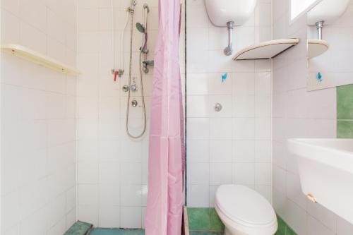 a bathroom with a pink shower curtain and a toilet at Casa Rosa a 50mt dal mare in Torre Santa Sabina