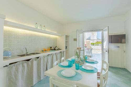 a kitchen with a table with plates on it at Casa Rosa a 50mt dal mare in Torre Santa Sabina