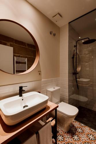 a bathroom with a sink and a toilet and a mirror at Palacio Condes de Cirac in Villalba de Rioja