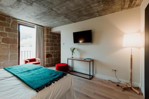 a bedroom with a bed and a television on the wall at Palacio Condes de Cirac in Villalba de Rioja