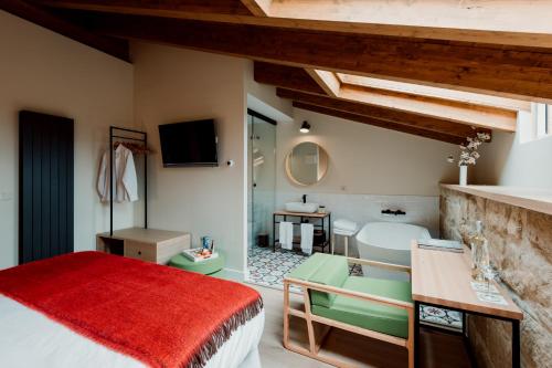 a bedroom with a bed and a bathroom with a tub at Palacio Condes de Cirac in Villalba de Rioja