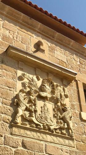 a stone sculpture on the side of a building at Palacio Condes de Cirac in Villalba de Rioja