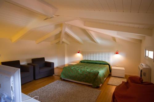 Hotel Muraglie في فيبو فالينتيا: غرفة نوم بسرير واريكة في غرفة