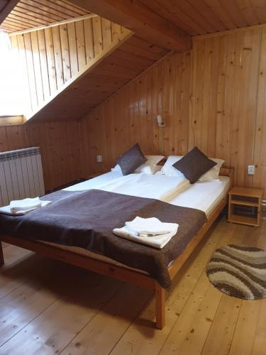 a bedroom with a large bed in a wooden room at Cabana Sarmis Costesti in Costeşti