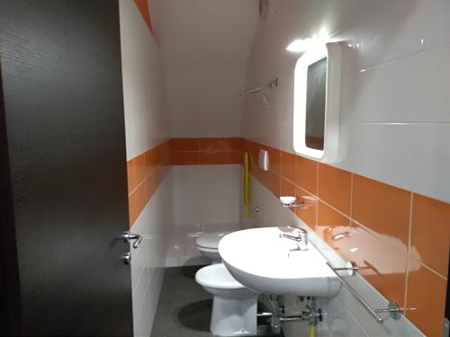 bagno con 2 servizi igienici, lavandino e specchio di Caterinette a Bisceglie